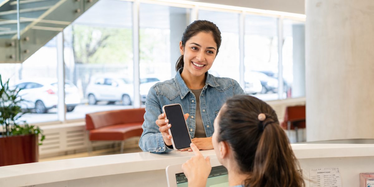A patient and a team member at the reception counter of a multi-provider clinic.