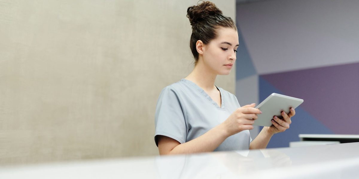 A clinic team member reviewing practice data on a tablet.
