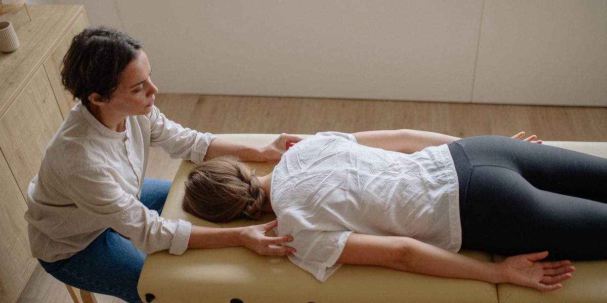 A chiropractor performing an adjustment on a patient in the treatment room.