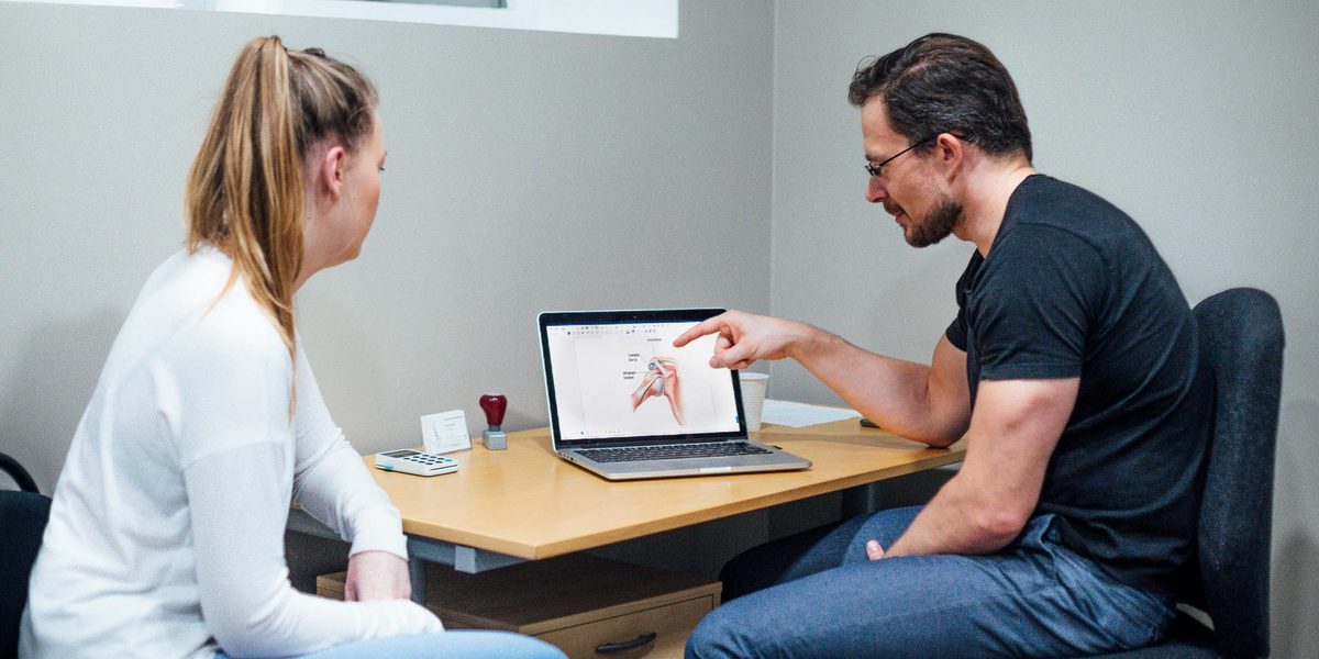 A chiropractor walking a patient through their treatment plan.