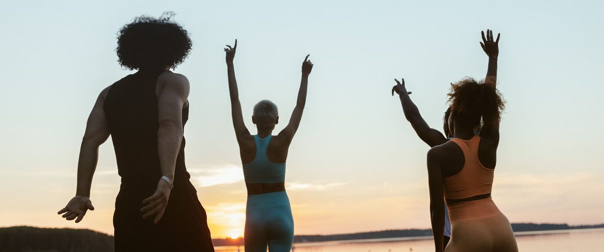 A group of patients back to an active life, celebrating outdoors at sunrise.