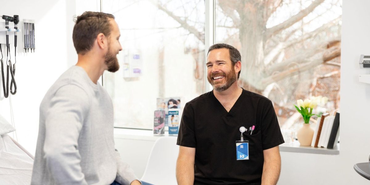 A chiropractor talking with a patient at the end of a visit.